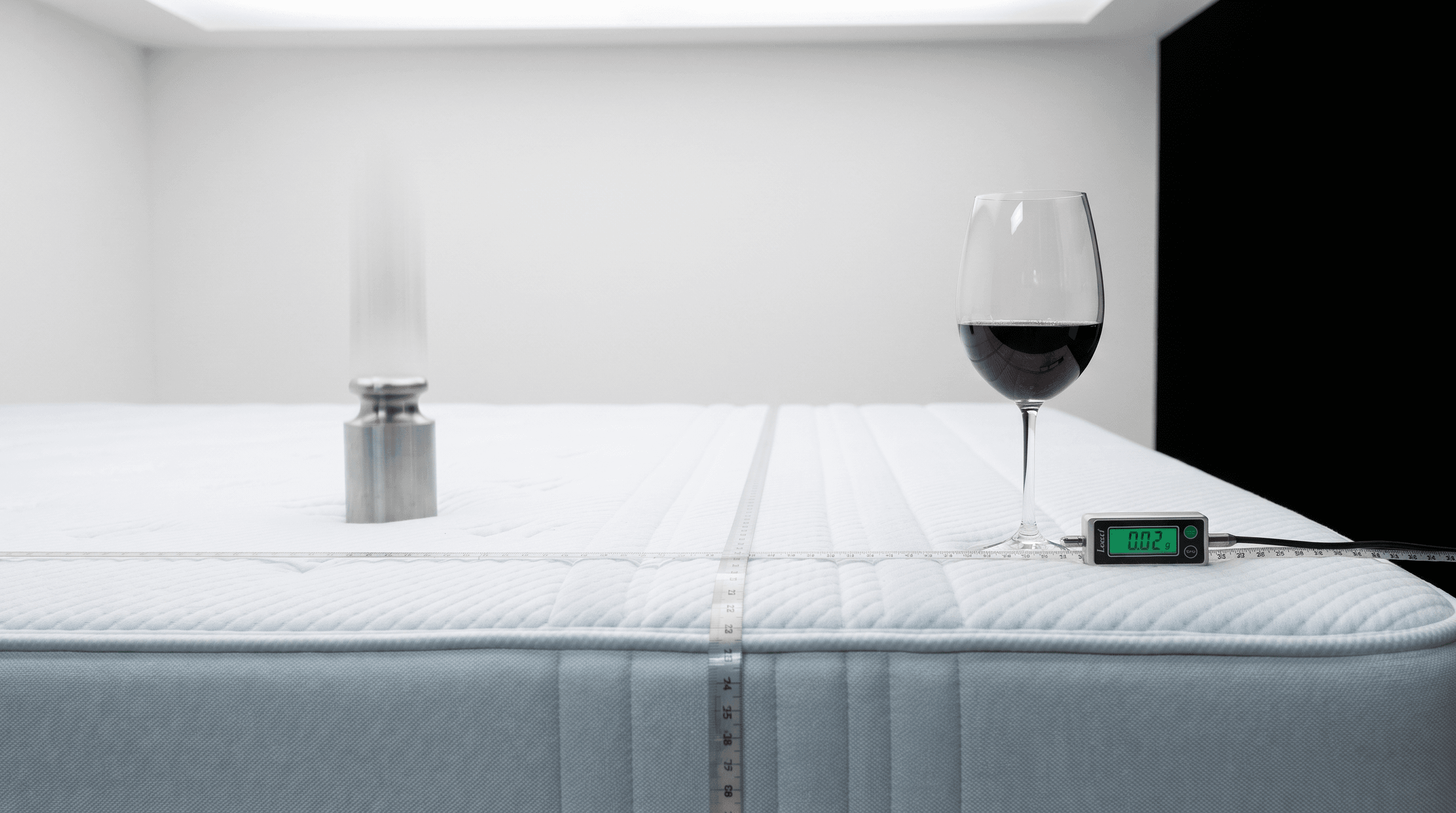 Wine glass standing still on the Leesa Sapira Chill Full while a weight is dropped on the other side