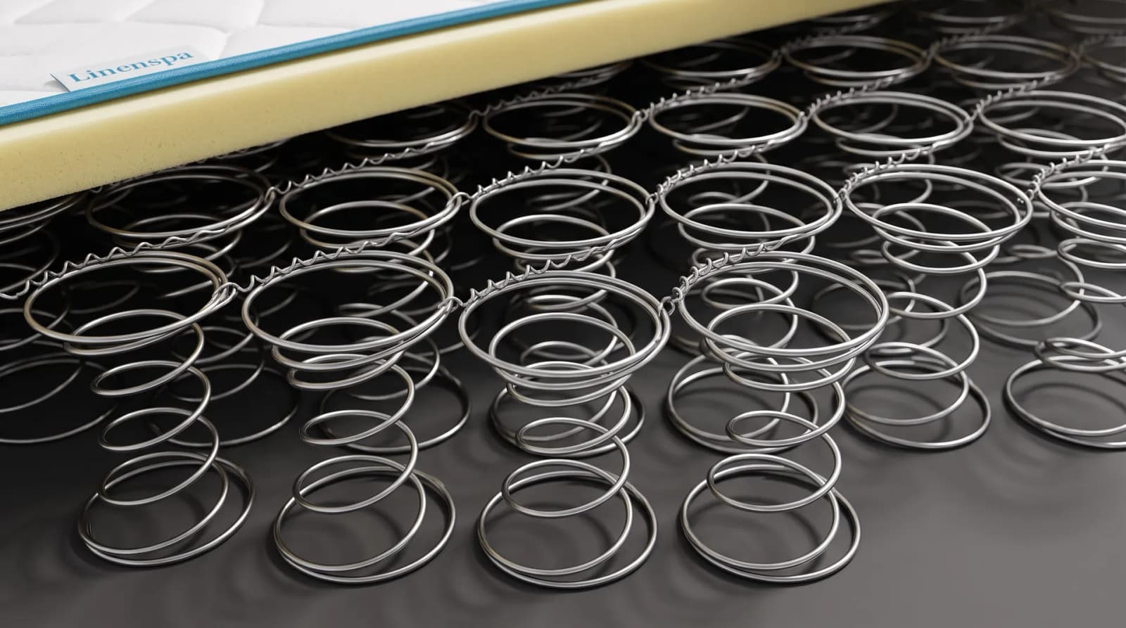 Close-up of polished steel Bonnell coils in a grid beneath a foam layer
